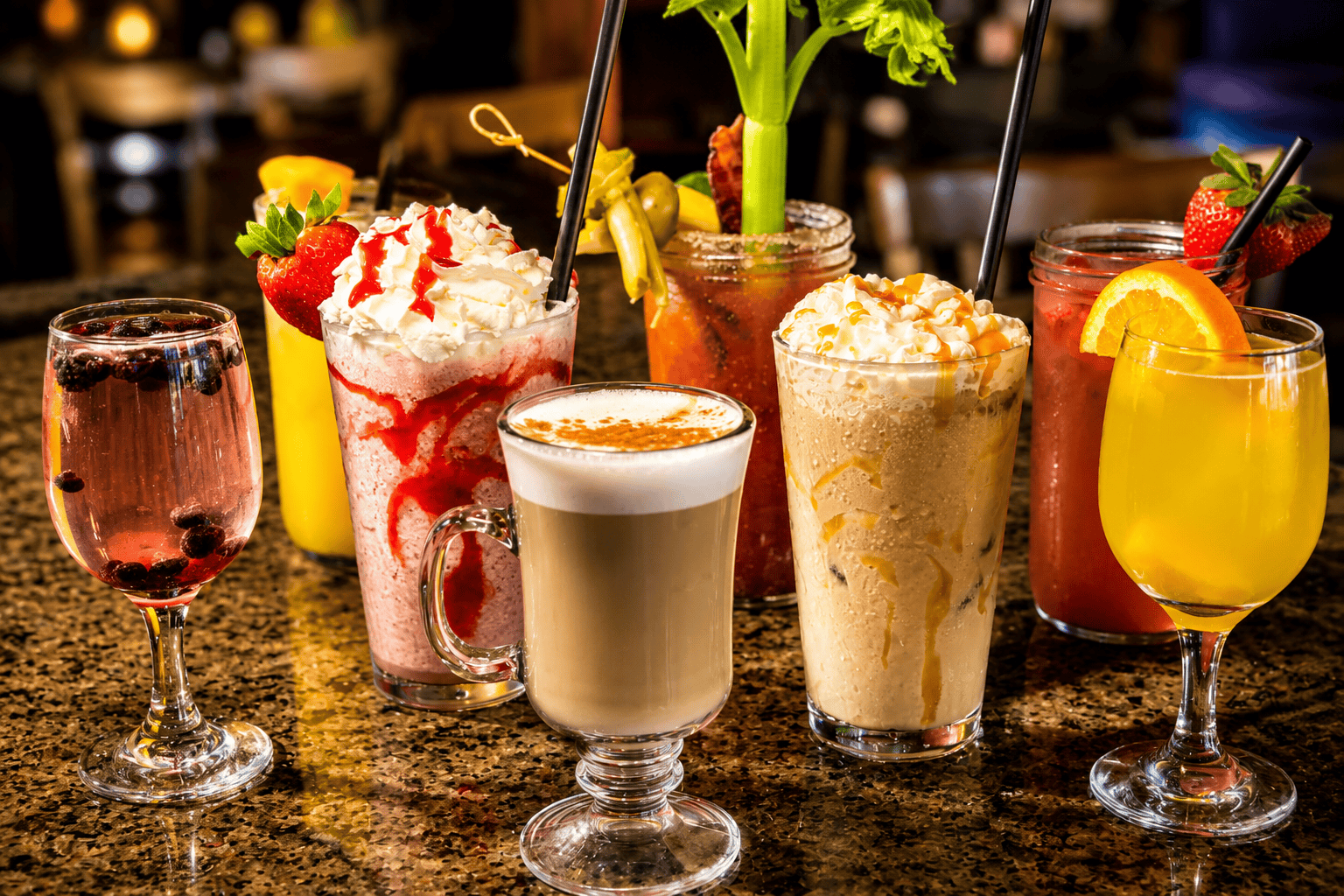 A lineup of specialty drinks — frozen strawberry, latte, iced caramel coffee, bloody mary and mimosa