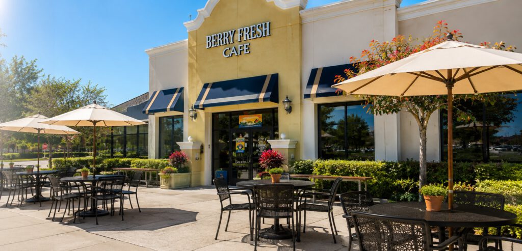 Berry Fresh Cafe storefront with shaded patio tables and umbrellas on a sunny day